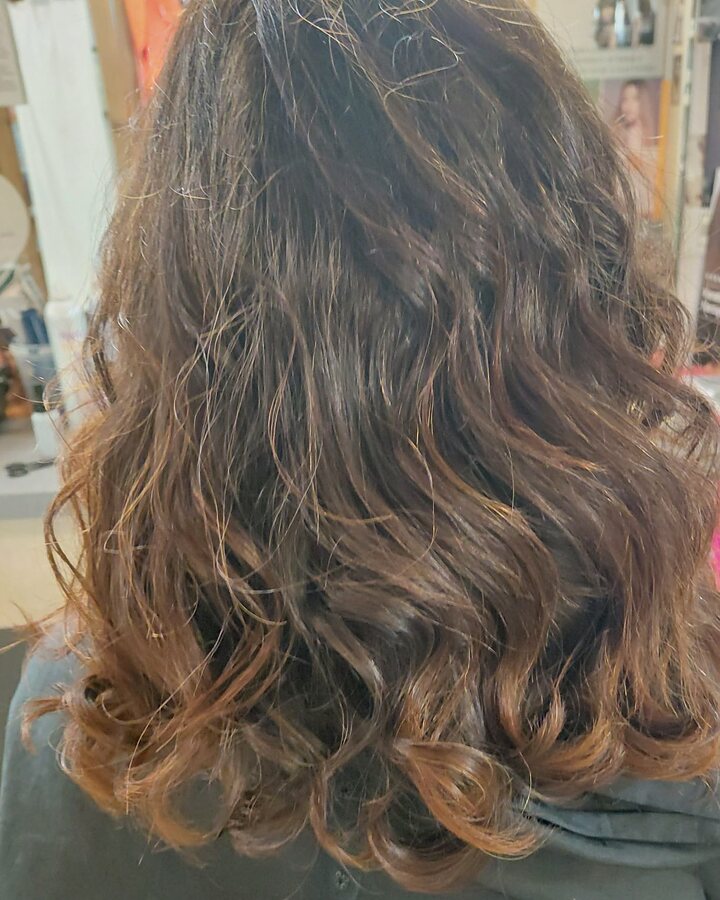 Capelli castani a onde morbide visti di spalle, con le punte ramate