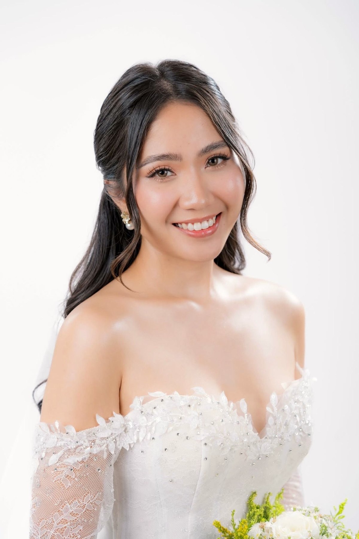 Sposa sorridente con acconciatura morbida e velo